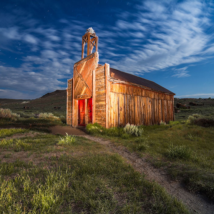 woman twirling a colored light against a night sky