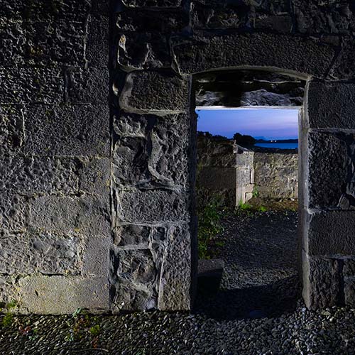 woman twirling a colored light against a night sky